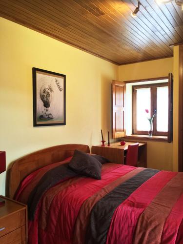 a bedroom with a large bed with a red blanket at Casa de São Sebastião in Manteigas