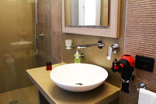 a white sink sitting under a mirror in a bathroom at Resort Il Mulino in Favignana