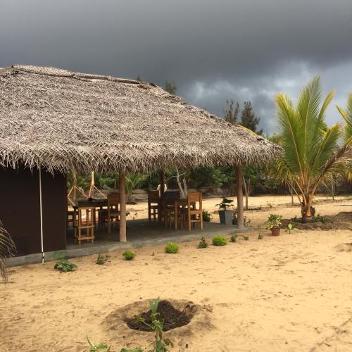 a hut with a straw roof on the beach at Kadjan villa in Arugam Bay