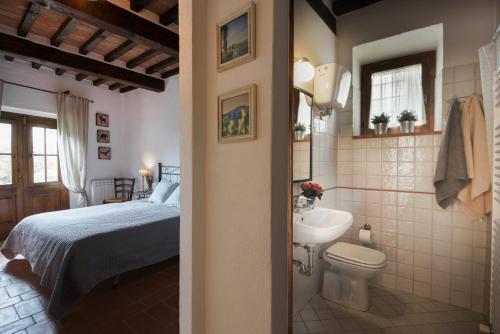 a bathroom with a bed and a toilet and a sink at In Toscana Camere in Monticchiello