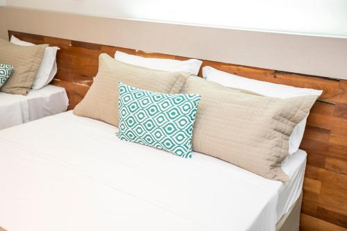 a bunch of pillows sitting on a bed at Hotel Pousada do Bosque in Ponta Porã