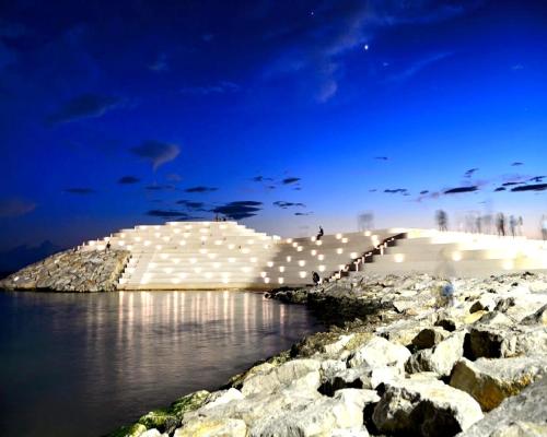 a bridge over a body of water at night at Maksimilian Apartament in Durrës