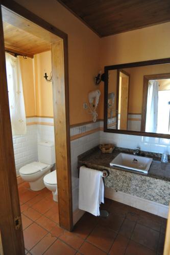 a bathroom with a sink and a toilet and a mirror at Hotel Rural Hosteria Fontivieja TR-CC-195 in Losar de la Vera
