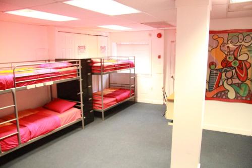 a room with three bunk beds with red sheets at Duo Housing in Washington