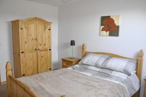 バリマネーにあるThe Place Aboveのベッドルーム1室(ベッド1台付)、木製キャビネットが備わります。