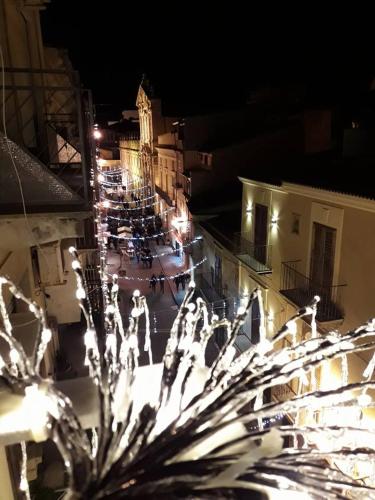 a group of people walking down a street at night at B&B Vittorio Emanuele in Licata