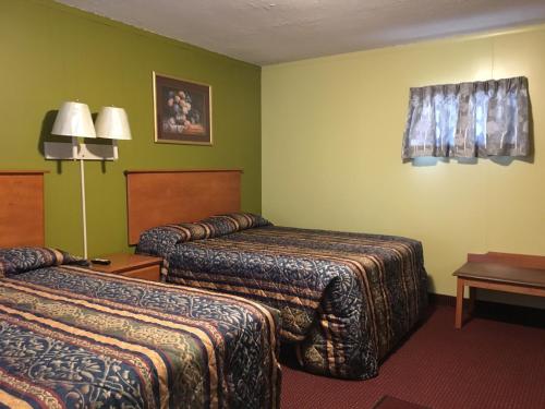 En eller flere senge i et værelse på Pine Ridge Motel