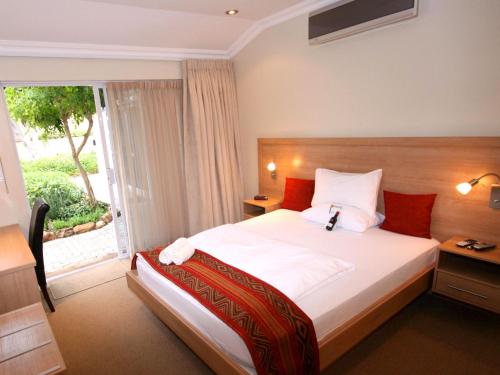 una camera d'albergo con letto e finestra di Hajos Lodge a Città del Capo