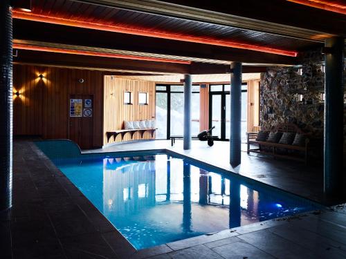 a swimming pool in a room with a couch at Astra Falls Creek in Falls Creek