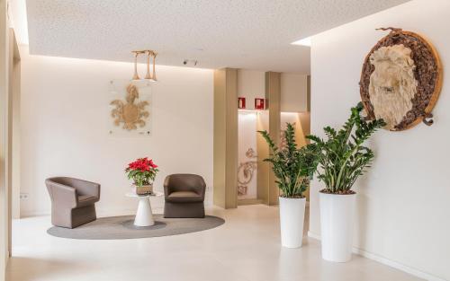a living room filled with furniture and a vase of flowers at Hotel Lleó in Barcelona