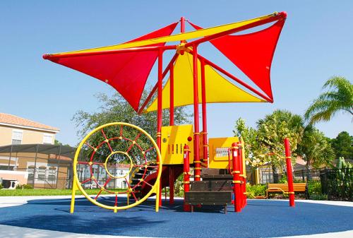 a playground with a red and yellow play structure at Encantada Resort Vacation Townhomes by IDILIQ in Kissimmee