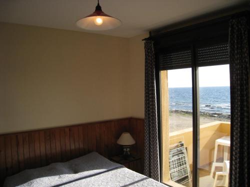 une chambre avec un lit et une vue sur l'océan dans l'établissement La Marine, à Luri