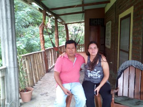 a man and a woman sitting on the porch of a house at Beach cabin ometepe in Altagracia