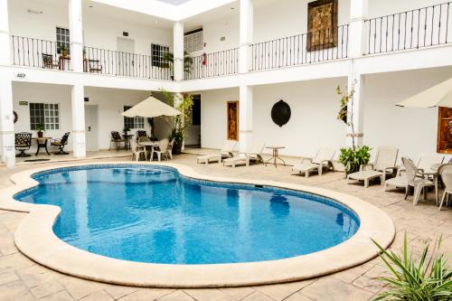 梅里達的住宿－瑪麗亞何塞酒店，庭院内的游泳池,配有桌椅