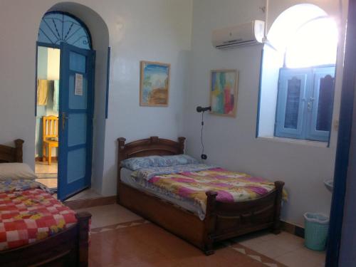 a bedroom with a bed and a blue door at Bet El Kerem Guesthouse in Aswan