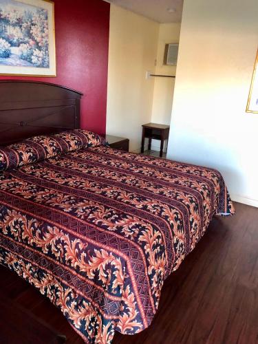a hotel room with a bed with a colorful bedspread at Cajun Inn Motel in Galliano