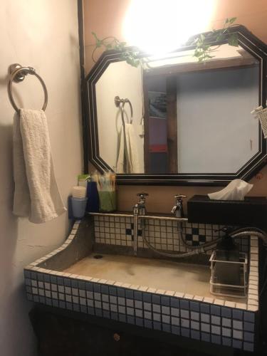 a bathroom with a sink and a mirror at Shabby House in Sapporo