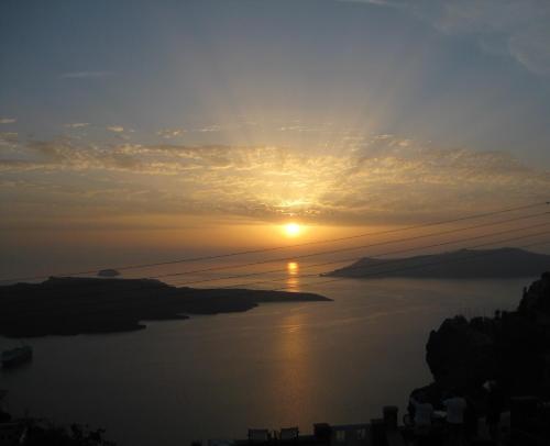 um pôr-do-sol sobre um corpo de água em Le Petit Greek em Fira