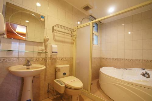 a bathroom with a sink and a toilet and a shower at Bao Kang Flower Farm in Nanzhuang