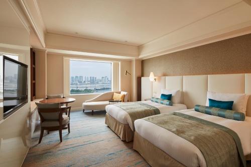 東京にあるグランドニッコー東京 台場のベッド2台と大きな窓が備わるホテルルームです。