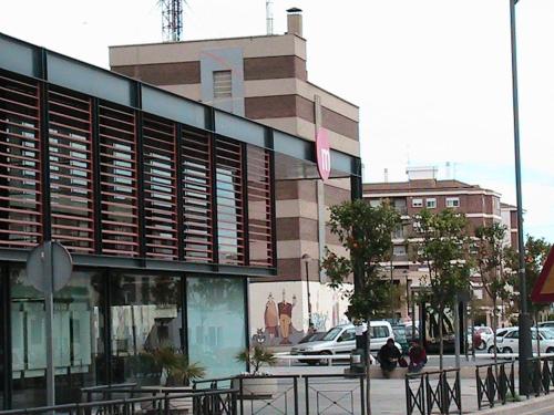 a building on the side of a street with cars at Hotel Manises in Manises