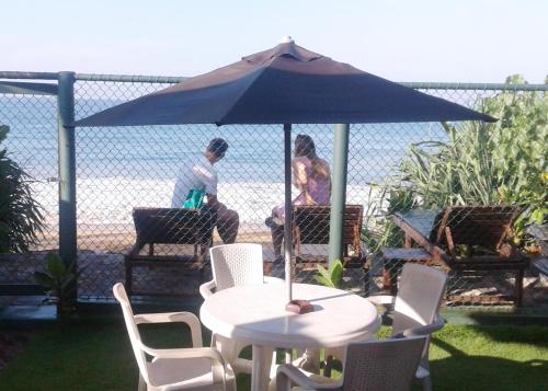 a table and chairs with an umbrella on a patio at Randiya Beach Villa in Galle