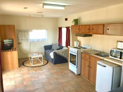 a small kitchen and living room with a couch at Cute Private Studio Flat with AIRCON! in Hay