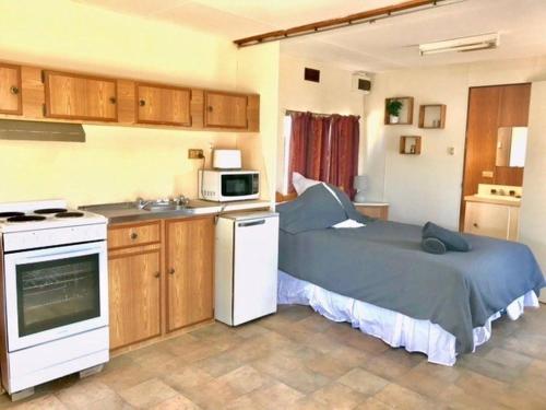 a small kitchen with a bed in a room at Cute Private Studio Flat with AIRCON! in Hay