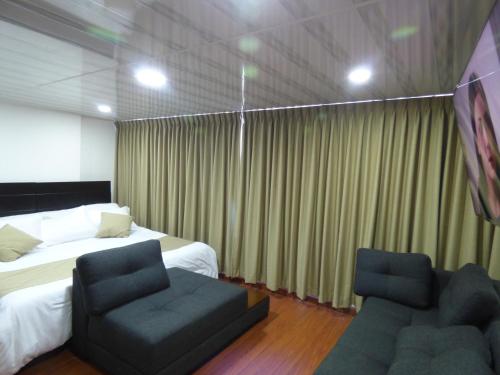a hotel room with two beds and two chairs at SUITE SANTA LUCIA HOTEL BOUTIQUE in Sogamoso