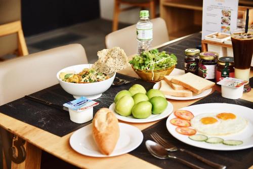 a wooden table with plates of food on it at Babylon Garden Da Nang in Da Nang