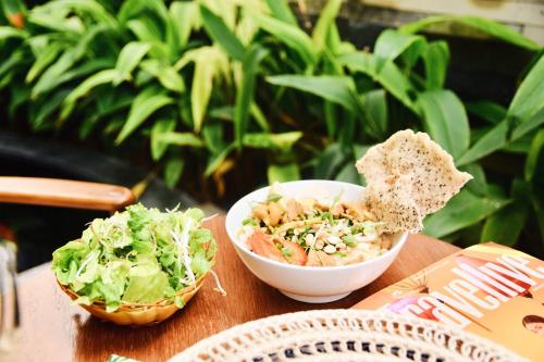 a bowl of food and a salad on a table at Babylon Garden Da Nang in Da Nang