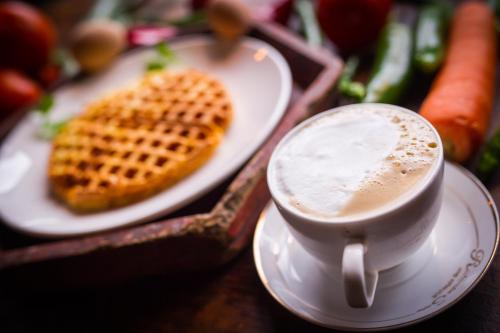a cup of coffee sitting next to a plate of food at Rural House in Yangshuo