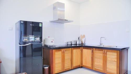 a kitchen with a black counter and a refrigerator at Vinh Hoang Hotel in Dong Hoi