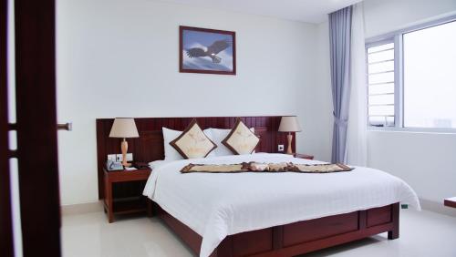 a bedroom with a large bed with white sheets at Vinh Hoang Hotel in Dong Hoi