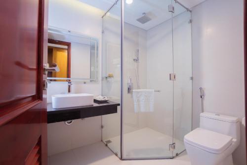 a bathroom with a shower and a toilet and a sink at Vinh Hoang Hotel in Dong Hoi