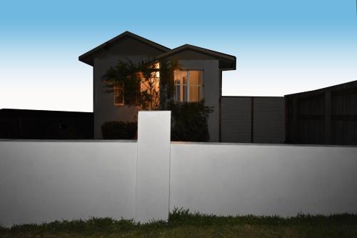 a white fence with a house in the background at Absolute Waterfront in Brisbane