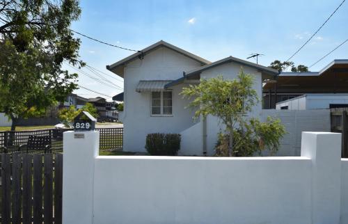 a white fence in front of a white house at Absolute Waterfront in Brisbane