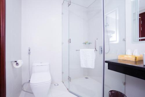 a bathroom with a toilet and a glass shower at Vinh Hoang Hotel in Dong Hoi