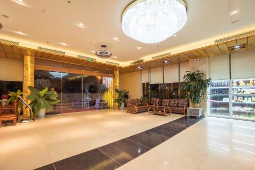 a lobby with couches and plants in a building at Vinh Hoang Hotel in Dong Hoi