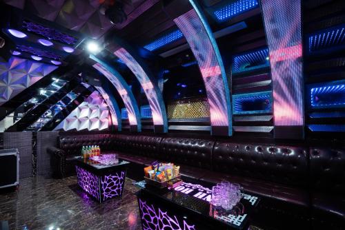 a bar with a leather bench and purple lights at Vinh Hoang Hotel in Dong Hoi