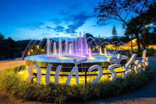 una fontana in mezzo a una strada di notte di Phukaew Resort & Adventure Park a Khao Kho