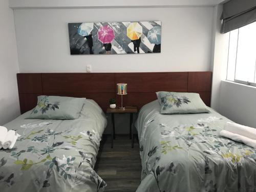 two beds sitting next to each other in a room at Cusco Cozy Apartment in Cusco