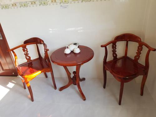 two chairs and a table with a tea set on it at Minh Kim Guesthouse in Ấp Phó
