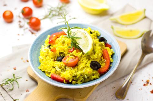 a blue bowl of rice with vegetables and a lime at Hotel Grace in Gwalior