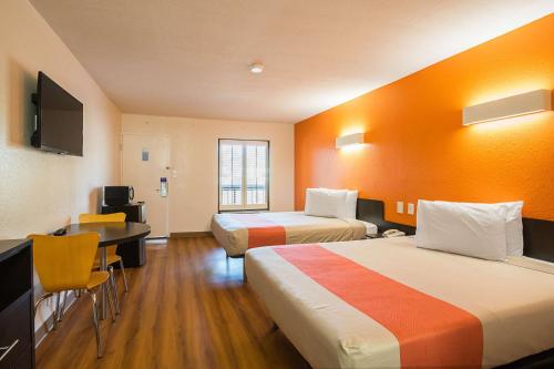 a hotel room with two beds and a desk at Motel 6-Savannah, GA - Midtown in Savannah