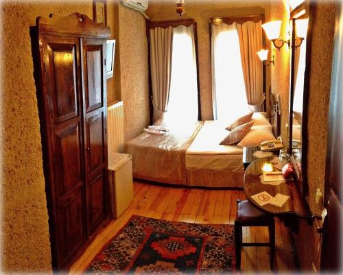 a bedroom with a bed and a table and a window at Naz Wooden House Inn in Istanbul