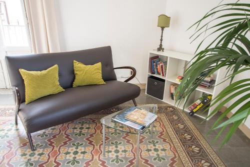 un soggiorno con divano nero e tavolino da caffè di Aria Rooms a Palermo