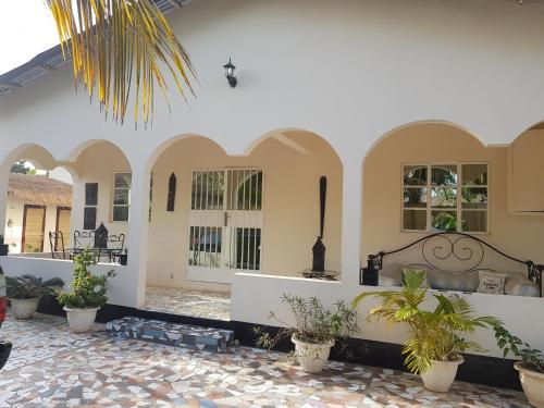 a courtyard of a house with potted plants at Mandinka Lodge in Kololi