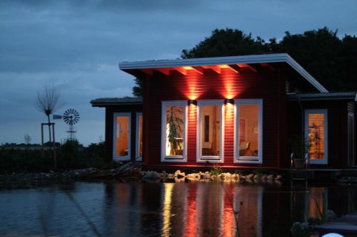 a small house with red lights in the water at Hotel & Restaurant Zum Kap Arkona in Putgarten