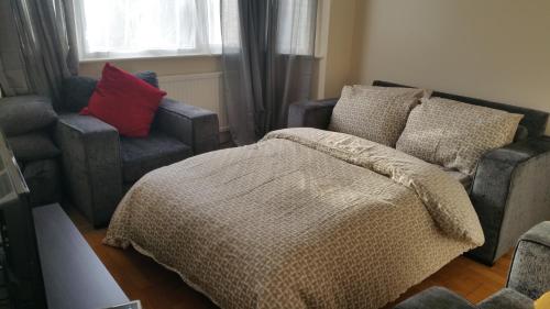 a bedroom with a bed and a couch and a chair at Elegant and spacious 2 bedroom in Barnet